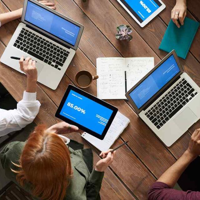 Team working at a table with laptops
